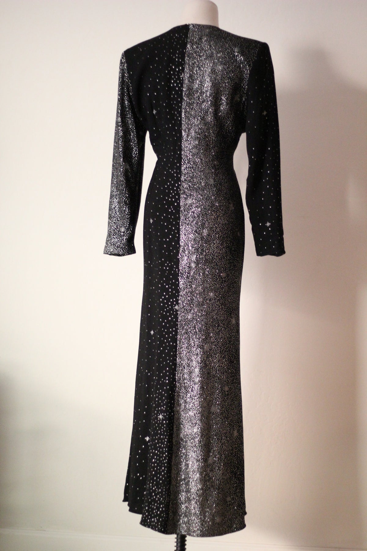 Full back view of Christian Lacroix AW 1998 runway dress featuring contrasting black and silver shimmering panels, long sleeves, a fitted waist, and a floor-length silhouette.