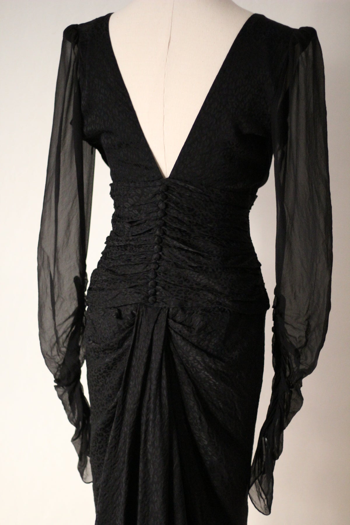 Close-up back view of Emanuel Ungaro FW 2006 black dress showing the back zipper, ruched waist, and sheer long sleeves