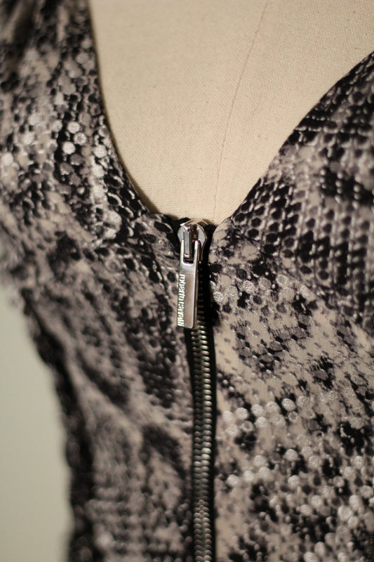 Close-up of the Roberto Cavalli Fall/Winter 2003 reflective snake print top featuring a plunging V-neckline and silver front zipper with engraved Roberto Cavalli branding.