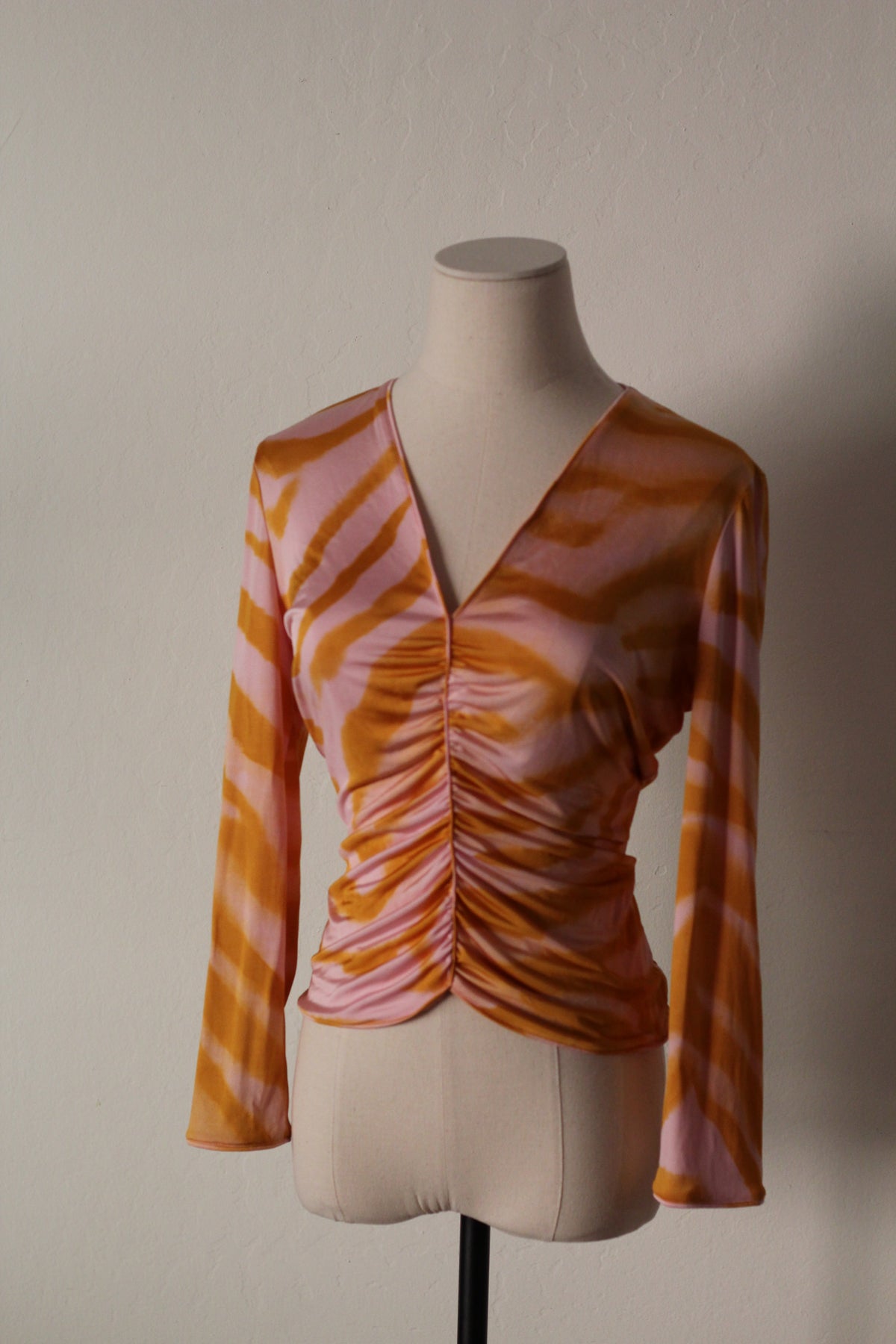 Vintage 2001 Ungaro by Giambattista Valli orange and pink printed long-sleeve top featuring a V-neckline and ruched front detailing.