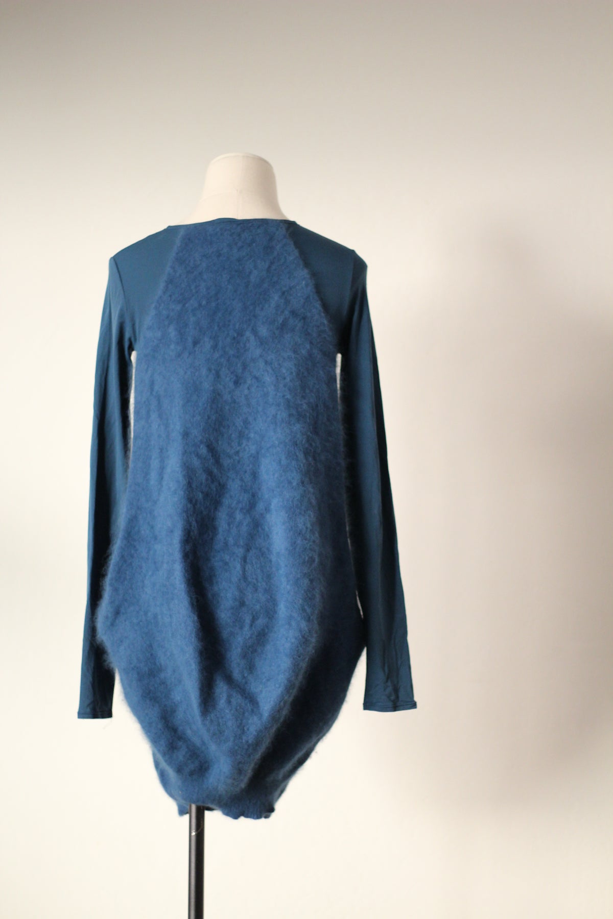 Back view of Alexander McQueen Fall/Winter 2007 blue angora sweater dress featuring a fuzzy textured back panel, long fitted sleeves, and a draped cocoon-shaped silhouette with a rounded hem.