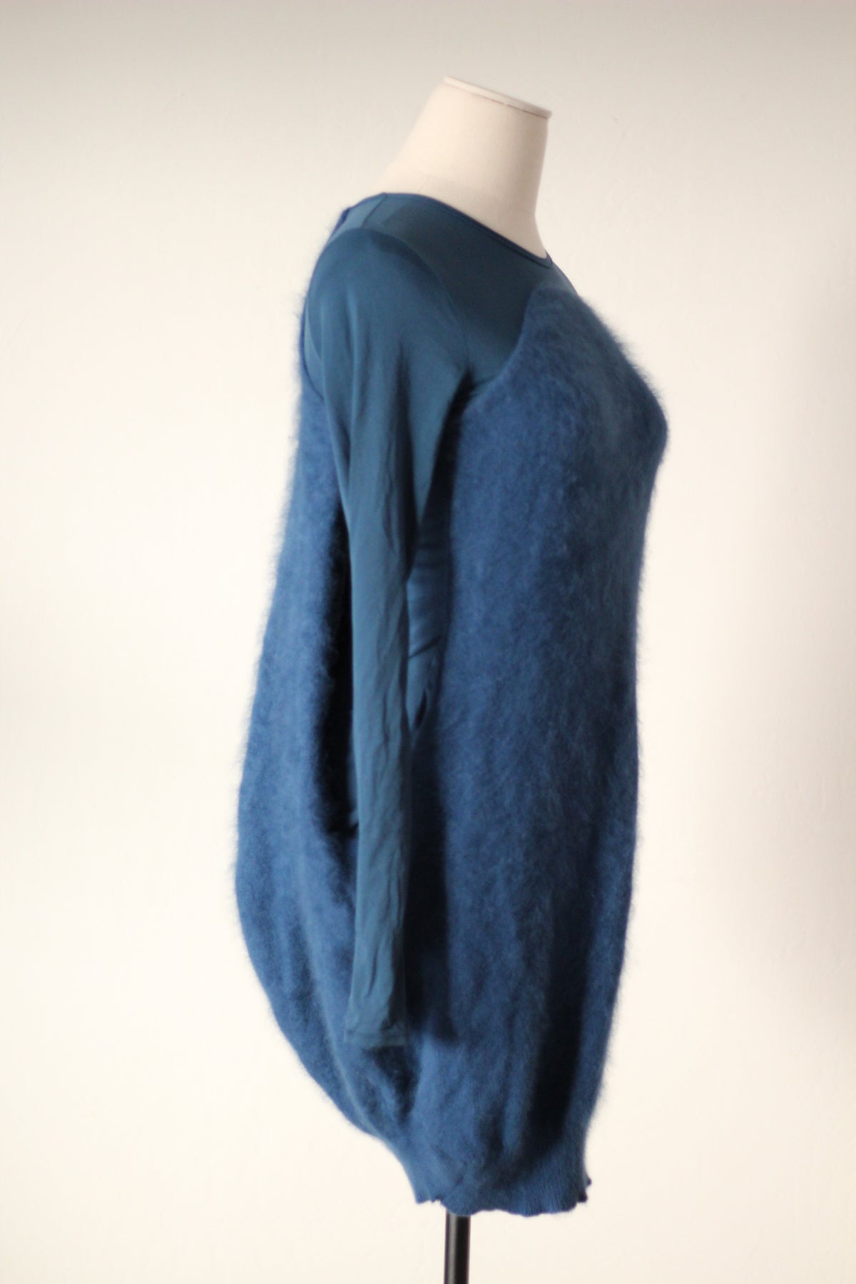 Side detail of Alexander McQueen Fall/Winter 2007 blue angora sweater dress showing the textured angora fabric, fitted long sleeve, and rounded cocoon silhouette.