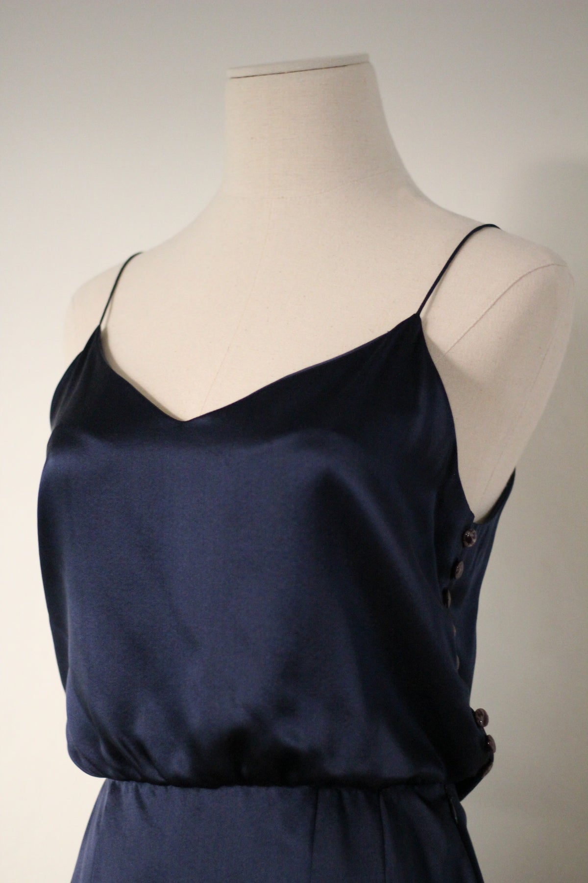 Close-up of the Chloé Spring/Summer 1999 navy blue silk runway dress featuring thin spaghetti straps, a softly draped neckline, and decorative side button detailing.