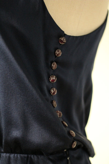 Close-up of the Chloé Spring/Summer 1999 navy blue silk runway dress featuring a row of decorative buttons along the side of the bodice. 