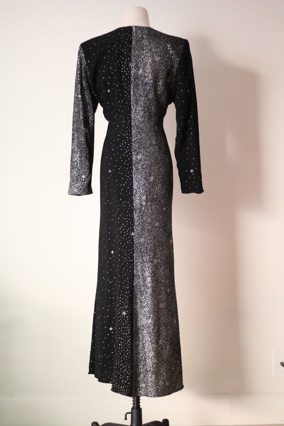 Back view of Christian Lacroix AW 1998 runway dress featuring an asymmetrical black and silver shimmering design, long sleeves, and a floor-length silhouette.