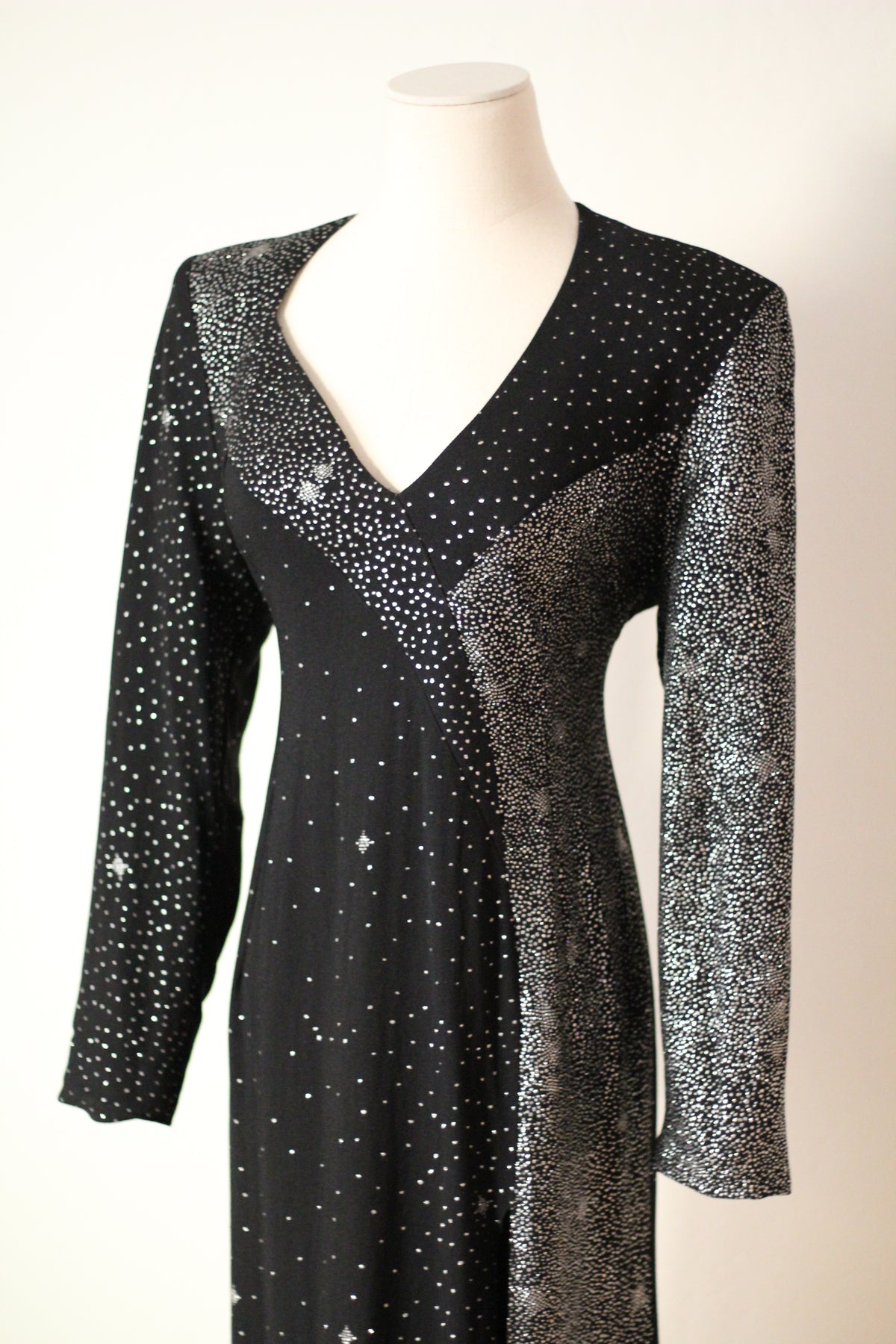 Close-up front view of Christian Lacroix AW 1998 runway dress featuring a deep V-neckline, long sleeves, and intricate silver sparkling embellishments on black fabric.