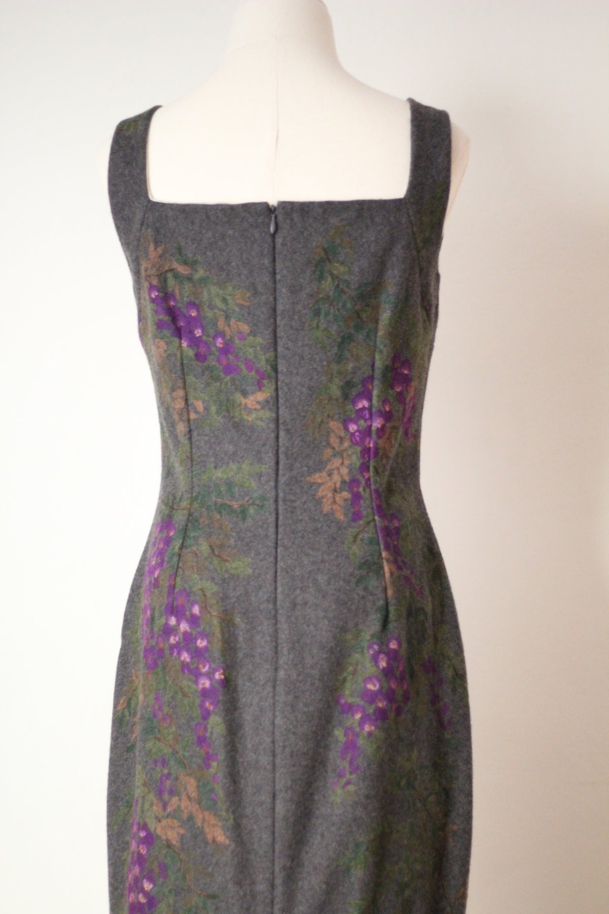 Close-up back view of vintage Dolce & Gabbana Fall/Winter 1998 runway dress featuring a square neckline, center back zipper, tailored seams, and painted purple wisteria flowers on gray wool fabric.