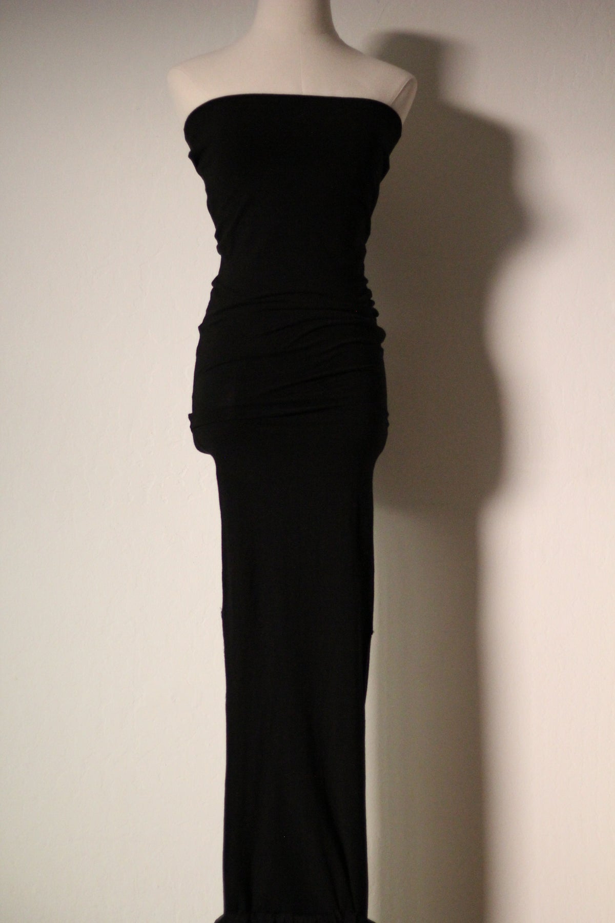 Upper front view of the black Dolce & Gabbana Fall/Winter 1991 gown, featuring a strapless neckline and ruched detailing through the waist and hips