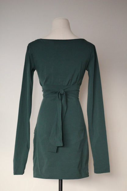 Back view of a dark green mini dress featuring a gathered waist and tied fabric belt, displayed on a mannequin