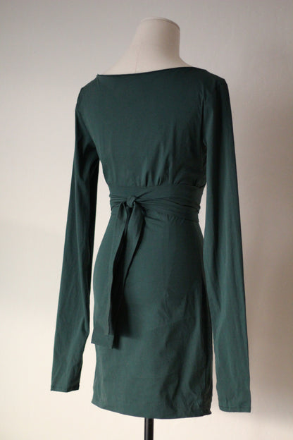 Back view of a dark green long-sleeve wrap mini dress with a tie waist and fitted silhouette, displayed on a mannequin