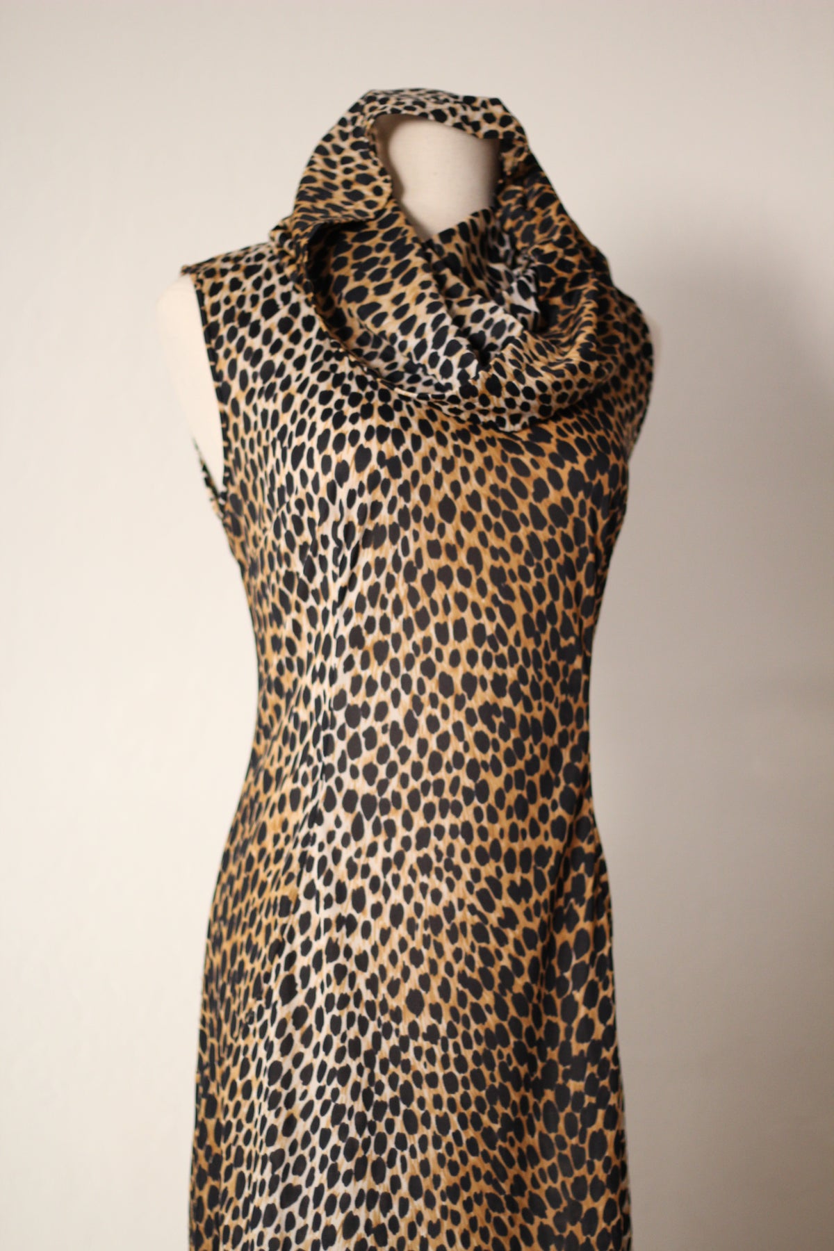 Close-up front view of Dolce & Gabbana Spring/Summer 1996 cheetah-print runway dress featuring a draped hood, sleeveless cut, fitted bodice, and allover animal print.