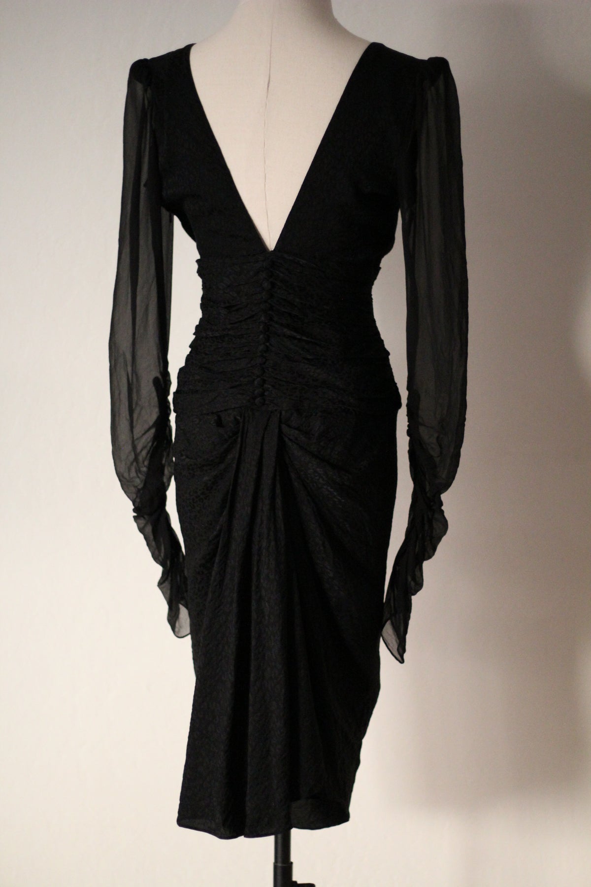 Full-length front view of Emanuel Ungaro FW 2006 black midi dress with sheer sleeves and a gathered fitted silhouette