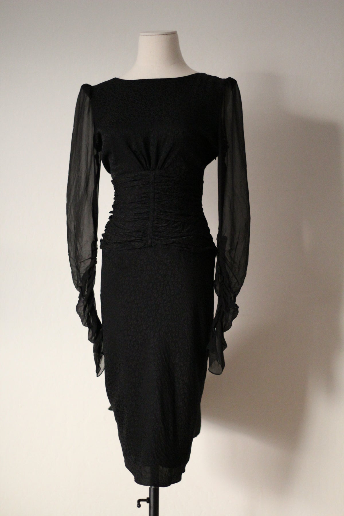 Close-up of the ruched waist, black patterned fabric, and sheer sleeves on an Emanuel Ungaro FW 2006 dress