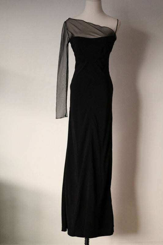 Black Richard Tyler Spring/Summer 1997 floor-length gown with an asymmetrical neckline, sheer mesh overlay, and long sleeve