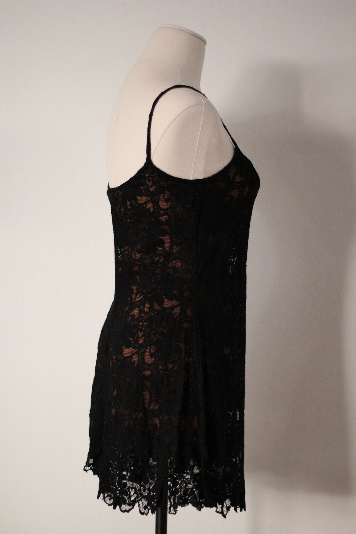 Opposite side view of Rifat Ozbek Spring/Summer 1994 black lace runway mini dress featuring thin spaghetti straps, a floral lace overlay, a fitted bodice, and a scalloped lace hem.