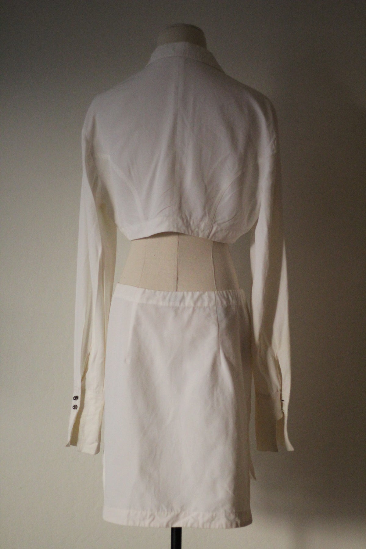 Back view of the Rifat Ozbek Spring/Summer 1994 white matching set featuring a cropped long-sleeve shirt and mini skirt.