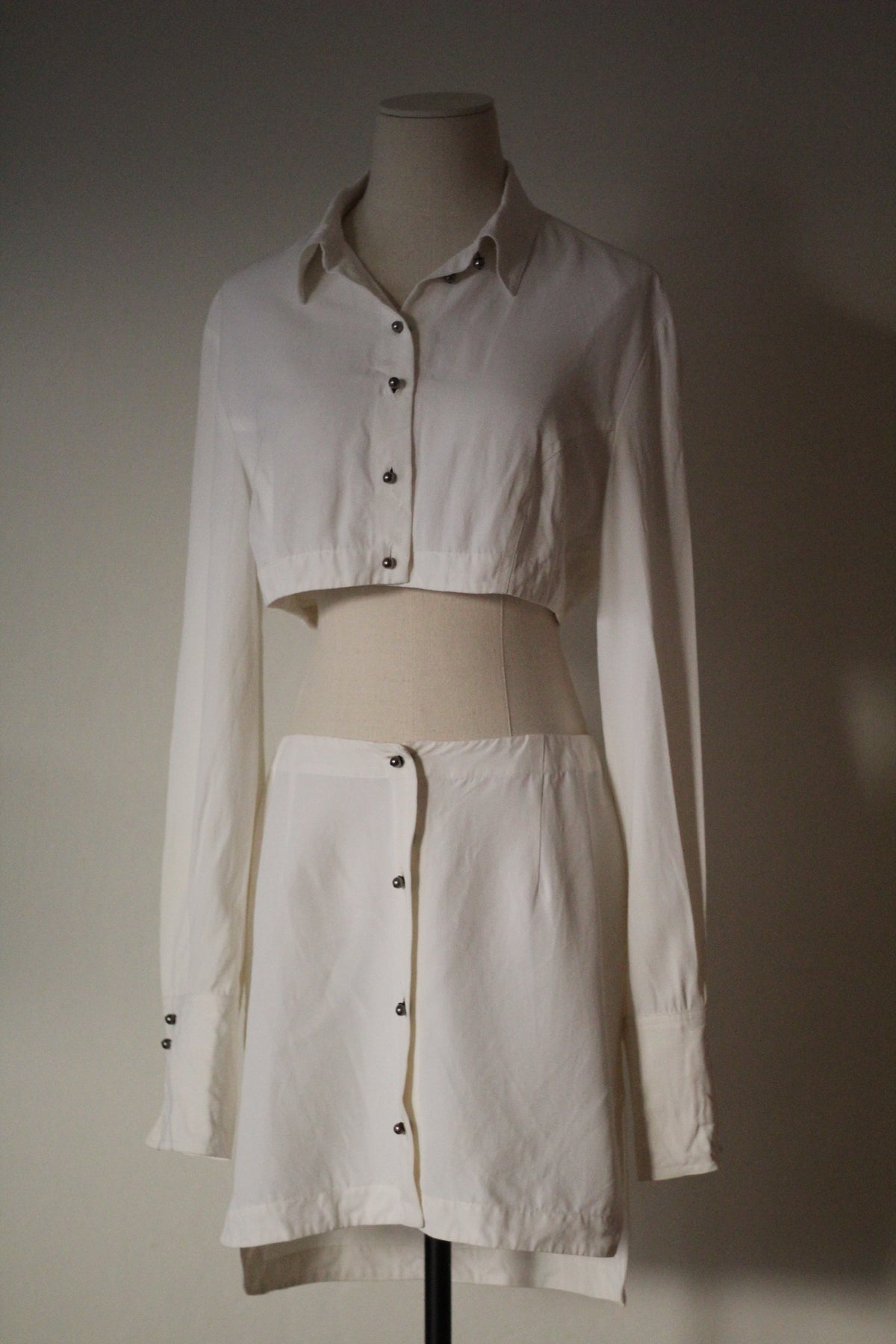 Full front view of the Rifat Ozbek Spring/Summer 1994 white matching set featuring a cropped button-front shirt and matching mini skirt. 