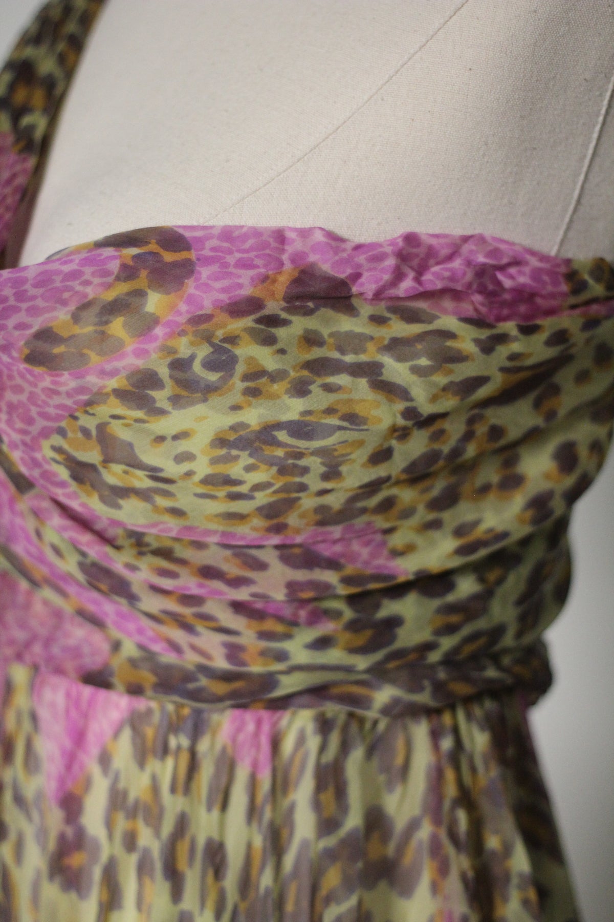 Close-up of Yves Saint Laurent 1993 leopard print silk dress in pink, olive green, and brown